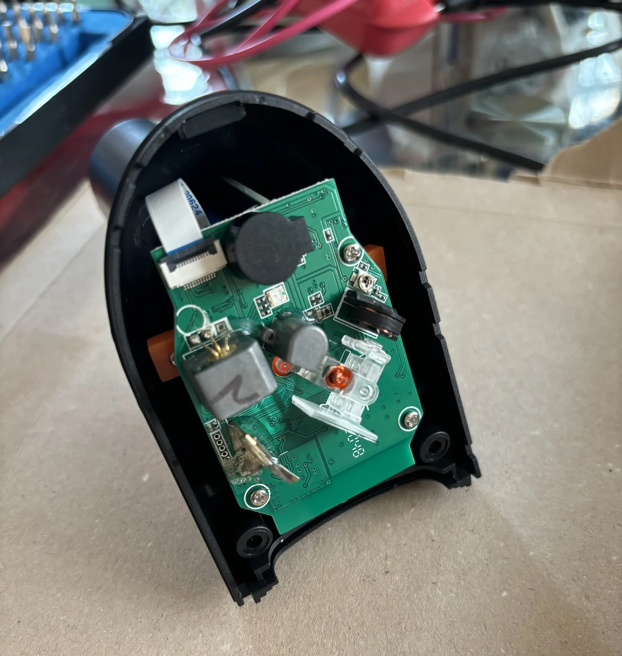 The wireless barcode scanner with the top taken off, revealing the motherboard with various components on it.