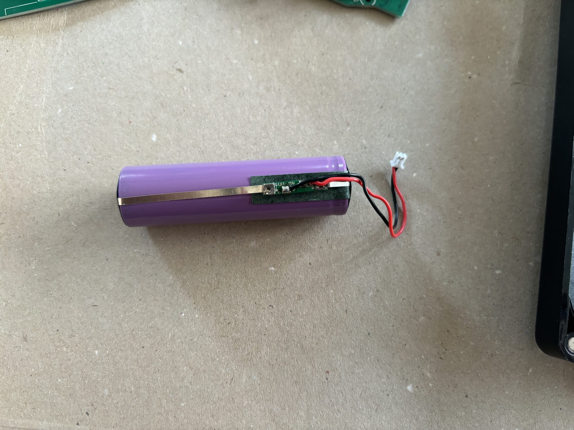 The battery with the plastic cover taken off and the protection circuit visible.