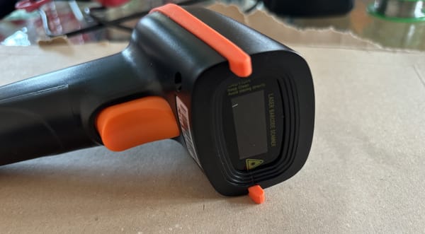 A photo of a handheld, wireless barcode scanner.